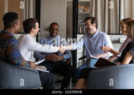 Partner commerciali felici che si battono le mani nelle trattative di gruppo in carica Foto Stock