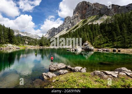 Ragazzo in piedi sulla roccia al lago doppio nella valle dei laghi di Triglav. Slovenia Foto Stock