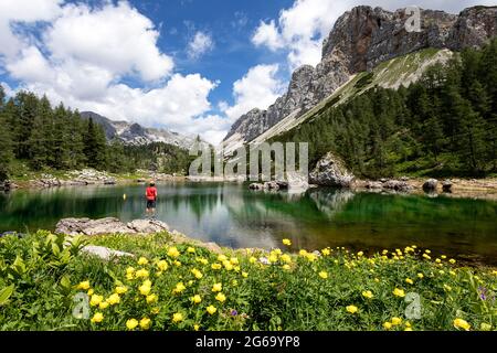 Ragazzo in piedi sulla roccia al lago doppio nella valle dei laghi di Triglav. Slovenia Foto Stock