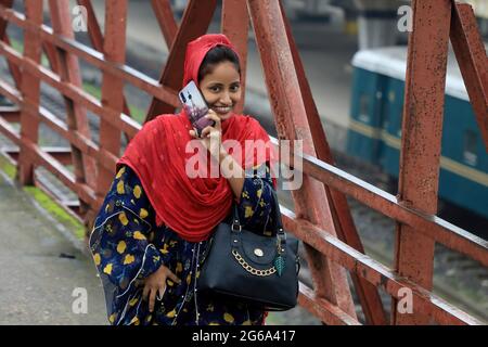 Dhaka, Bangladesh. 04 luglio 2021. Un operaio di indumenti parla al telefono mentre arriva alla fabbrica durante il blocco imposto dal governo per contenere la diffusione del coronavirus. (Foto di MD Manik/SOPA Images/Sipa USA) Credit: Sipa USA/Alamy Live News Foto Stock