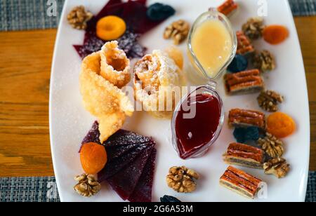 Vari dolci frutta secca, baklava, miele, marmellata nel caffè Foto Stock