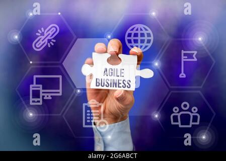 Firma di scrittura a mano Agile Business. La capacità di concetto di business di adattarsi rapidamente al mercato s è tendenza mano che tiene Jigsaw Puzzle pezzo sblocco Foto Stock