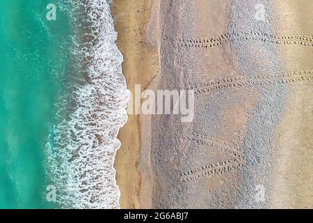 Le orme delle tartarughe che conducono dal mare attraverso una delle spiagge sabbiose di Cipro, riprese aeree direttamente sopra Foto Stock