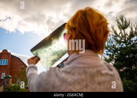 Donna che guarda l'eclissi solare attraverso immagini radiografiche Foto Stock