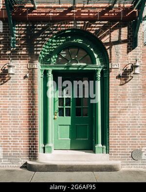 Una porta verde su un edificio in mattoni, West Village, New York City Foto Stock