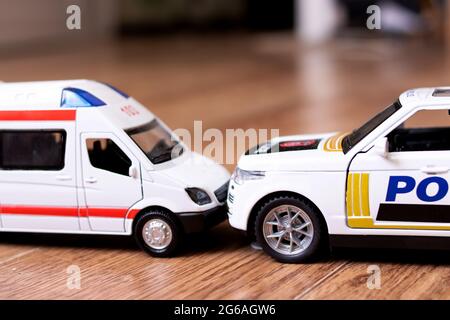 Collisione di Toy Ambulance Auto e polizia su pavimento in legno closeup Foto Stock