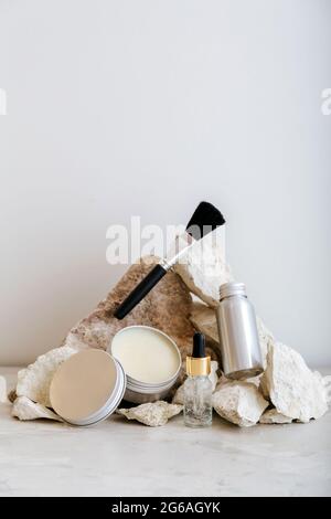 Set di prodotti cosmetici in confezione di alluminio. Prodotti cosmetici zero waste per la cura della pelle con disposizione a piedistallo in pietra color pastello. Estetica minima. Foto Stock