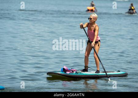 Acworth, Georgia, Stati Uniti. 4 luglio 2021. Una donna di 64 anni naviga sul lago Allatoona, Georgia, su una tavola da paddle per rimanere in salute e fisicamente in forma. Credit: Robin Rayne/ZUMA Wire/Alamy Live News Foto Stock