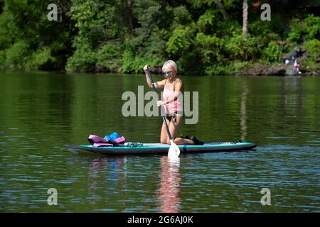 Acworth, Georgia, Stati Uniti. 4 luglio 2021. Una donna di 64 anni naviga sul lago Allatoona, Georgia, su una tavola da paddle per rimanere in salute e fisicamente in forma. Credit: Robin Rayne/ZUMA Wire/Alamy Live News Foto Stock