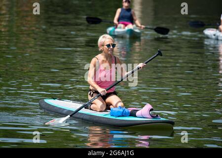 Acworth, Georgia, Stati Uniti. 4 luglio 2021. Una donna di 64 anni naviga sul lago Allatoona, Georgia, su una tavola da paddle per rimanere in salute e fisicamente in forma. Credit: Robin Rayne/ZUMA Wire/Alamy Live News Foto Stock