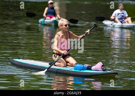 Acworth, Georgia, Stati Uniti. 4 luglio 2021. Una donna di 64 anni naviga sul lago Allatoona, Georgia, su una tavola da paddle per rimanere in salute e fisicamente in forma. Credit: Robin Rayne/ZUMA Wire/Alamy Live News Foto Stock