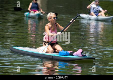 Acworth, Georgia, Stati Uniti. 4 luglio 2021. Una donna di 64 anni naviga sul lago Allatoona, Georgia, su una tavola da paddle per rimanere in salute e fisicamente in forma. Credit: Robin Rayne/ZUMA Wire/Alamy Live News Foto Stock