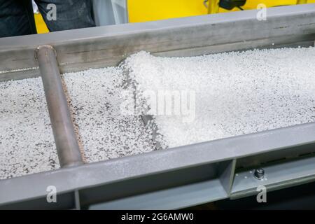 Granuli di plastica riciclata su nastro trasportatore automatico, shale shaker Foto Stock