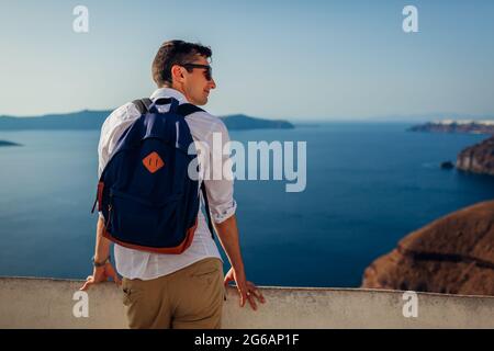 L'uomo che viaggia a Santorini si rilassa godendo la vista del paesaggio della Caldera a Fira, Grecia. Turismo, viaggio, vacanza estiva Foto Stock