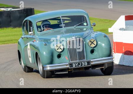 Jaguar Mk VII classica berlina, auto da corsa vintage in gara al St Marys Trophy al Goodwood Revival storico evento UK. Inclinazione in curva Foto Stock