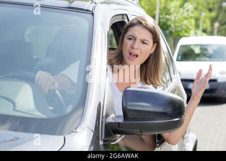 donna arrabbiata che guida un'auto Foto Stock