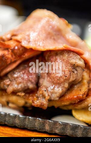 Delizioso piatto americano barbecue, bistecca, pancetta, salsiccia e patatine fritte Foto Stock