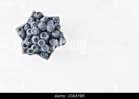 Mirtilli per il 4 luglio, mirtilli in ciotola a stella, su sfondo bianco Foto Stock