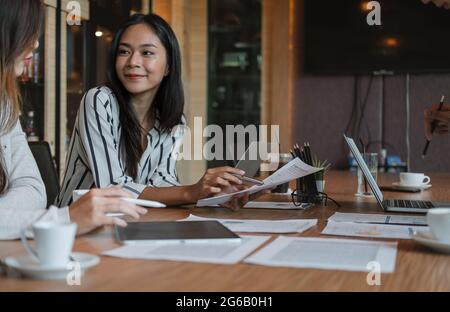 Gli uomini d'affari discutono i grafici e i grafici che mostrano i risultati del loro lavoro di squadra riuscito. Concetto di lavoro di squadra aziendale Foto Stock