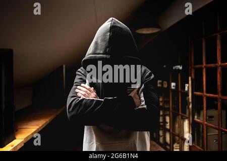 uomo anonimo nel buio cappuccio in piedi nella misteriosa posa Foto Stock