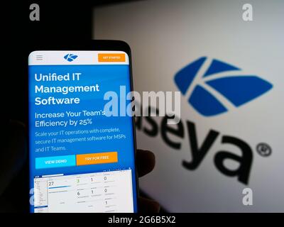 Persona titolare di smartphone con sito web della società americana DI gestione DELLA sicurezza IT Kaseya Limited su schermo con logo. Mettere a fuoco al centro del display del telefono. Foto Stock