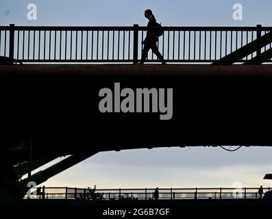 05 luglio 2021, Hessen, Francoforte sul meno: Una donna attraversa il ponte Ignatz Bubis la mattina presto. Foto: Arne Dedert/dpa Foto Stock