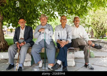 Anziani che riposano sotto l'albero a piazza, Hamedan (Hamadan), Provincia di Hamadan, Iran, Persia, Asia occidentale, Asia Foto Stock