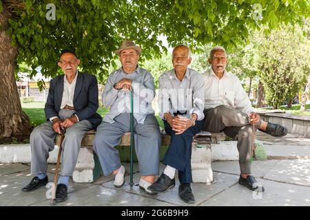 Anziani che riposano sotto l'albero a piazza, Hamedan (Hamadan), Provincia di Hamadan, Iran, Persia, Asia occidentale, Asia Foto Stock