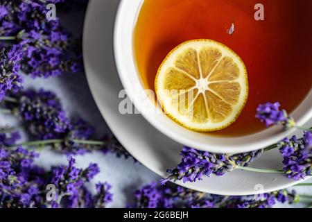 Tazza di tè con una fetta di limone, fiori di lavanda Foto Stock