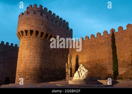 Statua di Santa Teresa di Gesù e le mura medievali della città di Avila al tramonto, Spagna Foto Stock