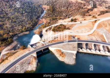 Diga di generazione di energia elettrica sul fiume Snowy nelle montagne innevate dell'Australia - Lago Jindabyne. Vista aerea dall'alto verso il basso su cancello e canale di scarico. Foto Stock