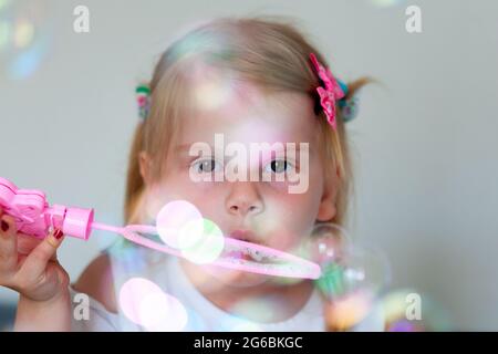 Un bambino soffia bolle, i bambini giocano con bolle di sapone Foto Stock