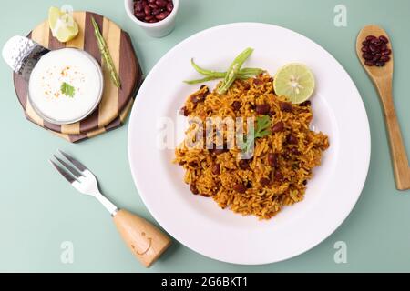 Cucina indiana - Kidney Beans Biryani, Rajma Pulao. Guarnito con coriandolo tritato e spicchi di limone. Rajma biryani servito con dahi. Foto Stock