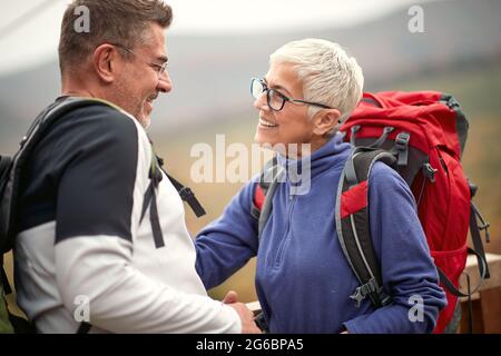 Una coppia anziana innamorata in una romantica escursione in collina in una bella giornata d'autunno Foto Stock