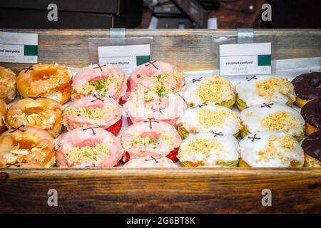 Un assortimento di ciambelle in mostra al Broadway Market, un mercato di strada a Hackney, Londra Est Foto Stock