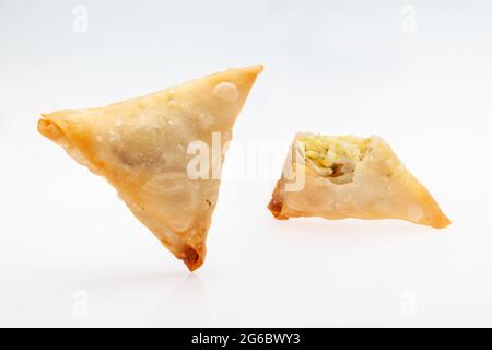 Samosa di patate con ripieno interno isolato su fondo bianco Foto Stock