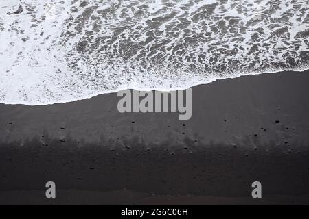 Onde sulla spiaggia di sabbia nera con spazio per le copie. Bellezza nella natura a Tenerife. Isole Canarie, Spagna. Foto Stock