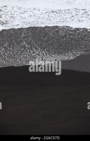 Onde sulla spiaggia di sabbia nera con spazio per le copie. Bellezza nella natura a Tenerife. Isole Canarie, Spagna. Foto Stock