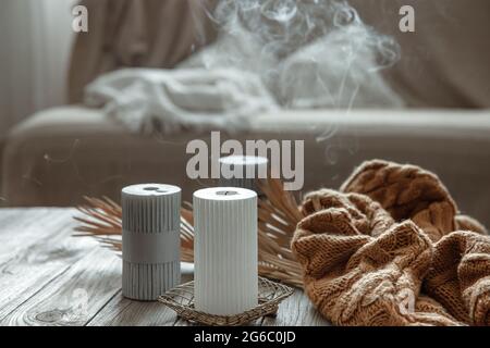 Accogliente composizione domestica con candele estintate su un tavolo di legno con un elemento a maglia. Foto Stock