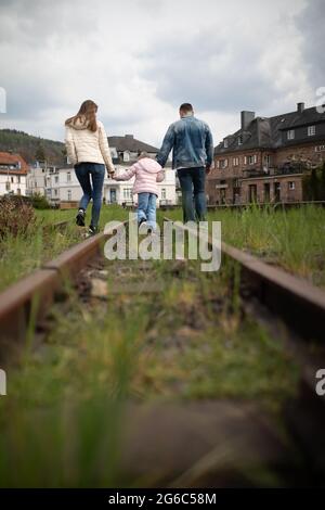 Famiglia con bambino passeggiata lungo la ferrovia. Foto Stock