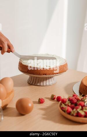 Diffondere la crema sul pan di spagna. Facendo rosso processo di velluto Foto Stock