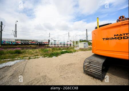 05 luglio 2021, Amburgo: Un TRENO ICE della Deutsche Bahn attraversa il cantiere della nuova stazione di Amburgo-Altona, con un escavatore in primo piano. Dopo diversi anni di ritardo, sono iniziati i lavori di costruzione della nuova stazione ferroviaria di Altona ad Amburgo. La stazione della S-Bahn di Diebsteich è in fase di costruzione e sostituirà la stazione di Altona, situata a circa due chilometri a sud, per i servizi regionali e interurbane nel 2027. Foto: Daniel Reinhardt/dpa Foto Stock