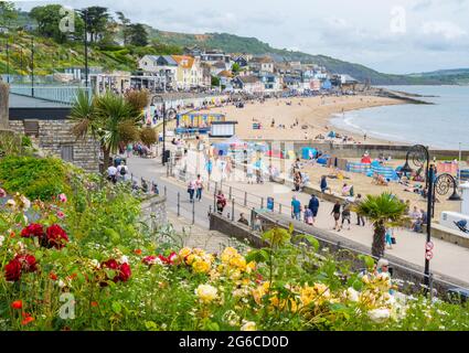Lyme Regis, Dorset, Regno Unito. 5 luglio 2021. Regno Unito Meteo. Un piacevole inizio caldo e soleggiato della settimana sulla Costa Giurassica. Le persone godono di caldo, luce solare frizzante sulla spiaggia presso la pittoresca località balneare di Lyme Regis il giorno in cui il governo è fissato per annunciare ulteriore allentamento delle restrizioni dal 19 luglio. Credit: Celia McMahon/Alamy Live News Foto Stock
