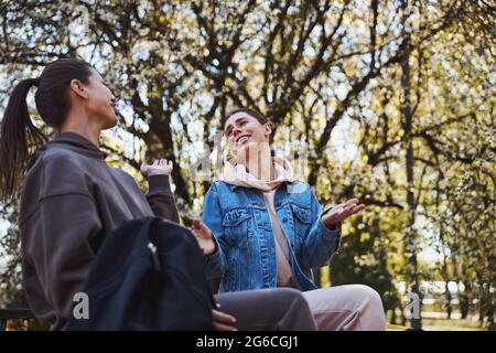 Due amici femminili che condividono i gossip l'uno con l'altro Foto Stock