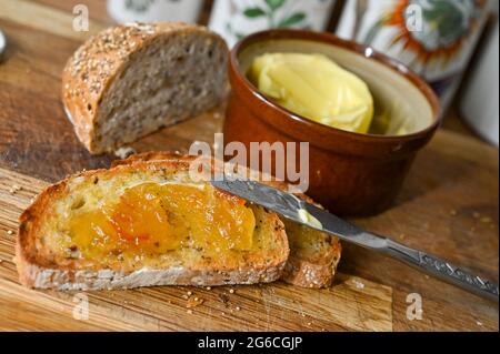 Toast al granaio con burro e marmellata per colazione su tavola di legno fotografia fatta da Simon Dack Foto Stock