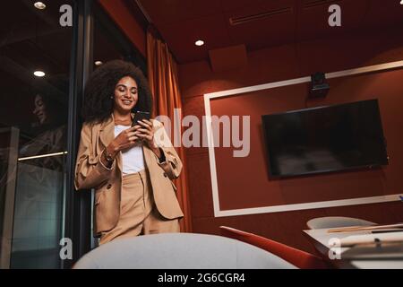 Donna Mirtful in piedi nella sala riunioni vicino alla porta Foto Stock