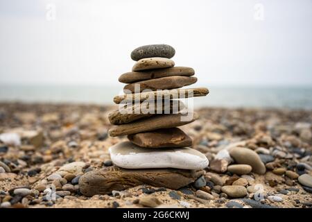 Tiny Stone Cairn su Rocky Beach Shore del lago Michigan Foto Stock