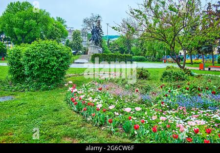 I colorati letti floreali nel parco, situato in Piazza Kontraktova (Piazza dei contratti) con una vista sul monumento equestre di Petro Sahaidachny, Kyi Foto Stock