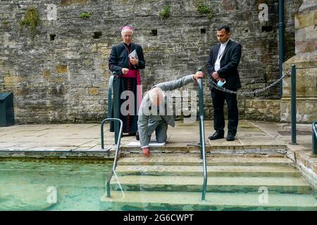 Il Principe di Galles (centro) tocca l'acqua curativa durante una visita al pozzo di San Winefride, nel Flintshire, nel Galles del nord, come Vescovo di Wrexham Peter Brignall (a sinistra) e Parroco cattolico romano di Holywell, Padre Justin Karakadu (a destra) Guardate, sul popolare sito di pellegrinaggio cattolico, Come parte di un tour di una settimana del Galles per la settimana del Galles. Data immagine: Lunedì 5 luglio 2021. Foto Stock