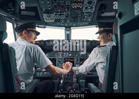 Due aviatori professionisti seduti nell'abitacolo durante il decollo Foto Stock